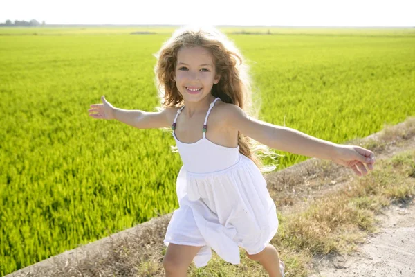 Correr brazos abiertos niña feliz en la pista del prado — Foto de Stock