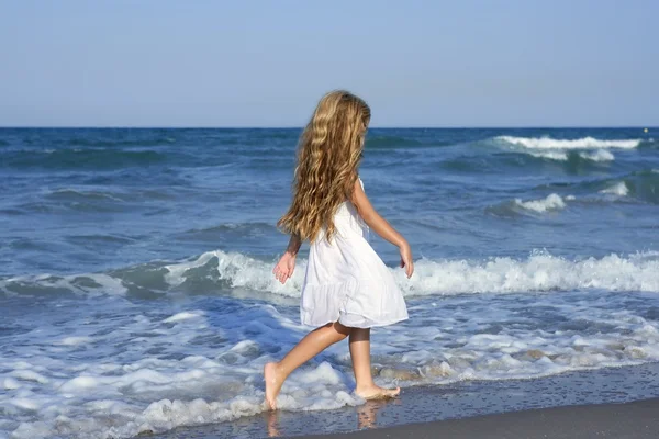 Malá holčička běží pláž v modrém moři — Stock fotografie