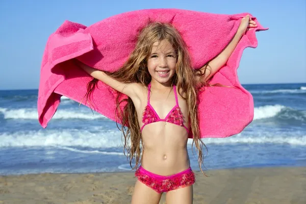 Praia menina jogando toalha rosa e vento — Fotografia de Stock