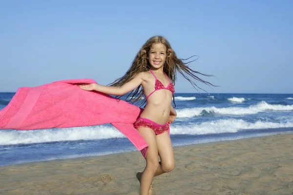 Spiaggia bambina giocare rosa asciugamano e vento — Foto Stock