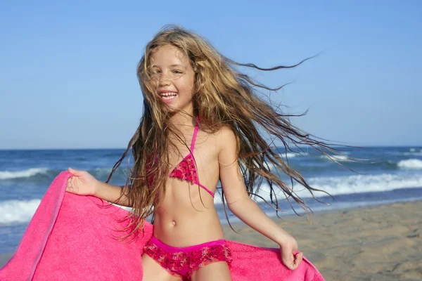 Praia menina jogando toalha rosa e vento — Fotografia de Stock