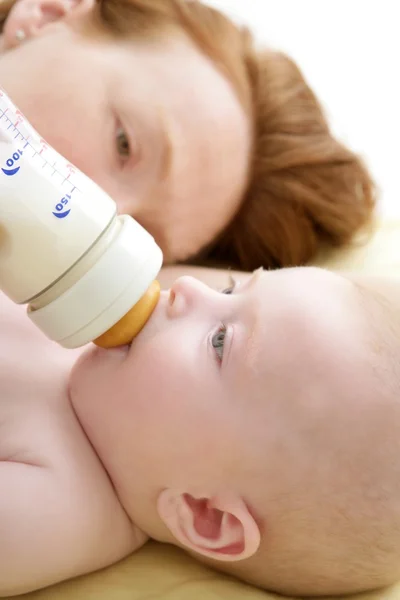 母は彼女の赤ちゃんにミルクのボトルを与える餌 — ストック写真