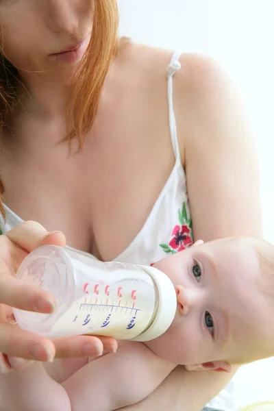 Mother feeding giving a milk bottle to her baby — Stock Photo, Image