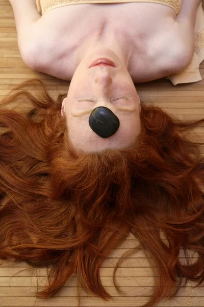 Redhead woman with black stones treatment — Stock Photo, Image
