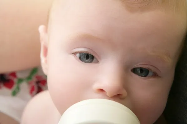 Baby blond meisje voeding consumptiemelk — Stockfoto