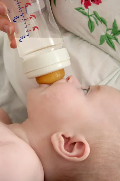 Baby blond little girl feeding drinking milk — Stock Photo, Image