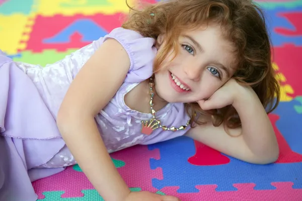Vacker prinsessa liten flicka leende liggande golv — Stockfoto