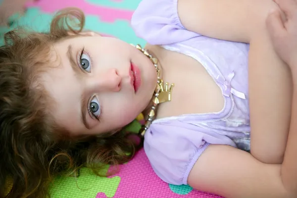 Schöne blaue Augen kleines Mädchen auf dem Boden liegend — Stockfoto