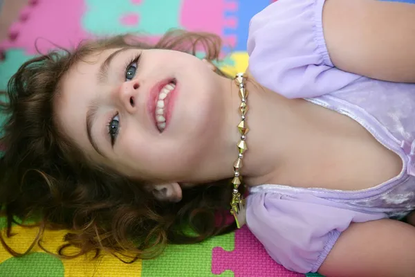 Krásná princezna malá holčička s úsměvem leží podlahové — Stock fotografie