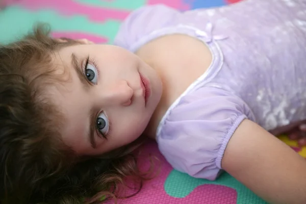 Vackra blå ögon lilla flickan liggande på golvet — Stockfoto