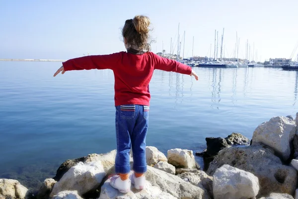 Little girl open arms looking marina blue sea — Stock Photo, Image