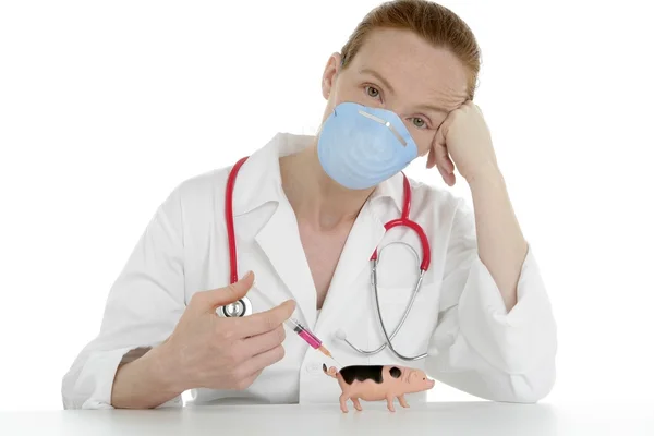 Лікар зі шприцом для грипу та іграшковою свинею — стокове фото