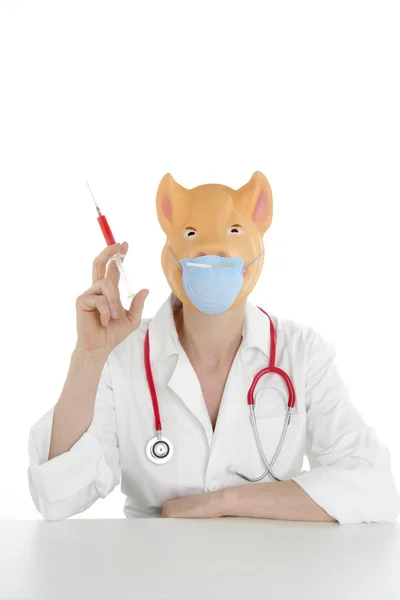 Médico con máscara de cerdo y jeringa roja —  Fotos de Stock