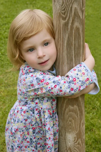Hermosa niña pequeña abrazar un tronco —  Fotos de Stock