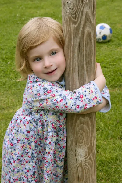 Menina pequena bonita abraçar um tronco — Fotografia de Stock