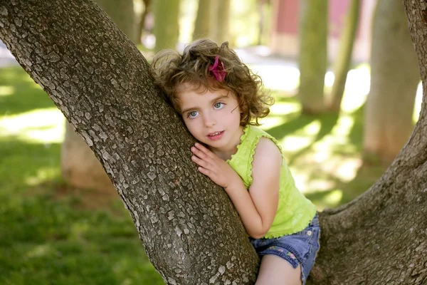 Mooie blauwe ogen klein meisje in het park-boom — Stockfoto