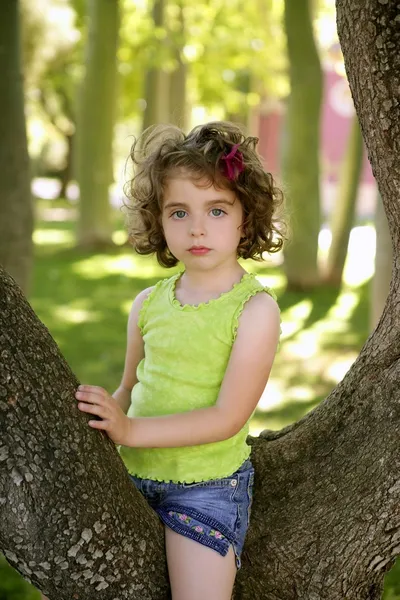 Mooie blauwe ogen klein meisje in het park-boom — Stockfoto