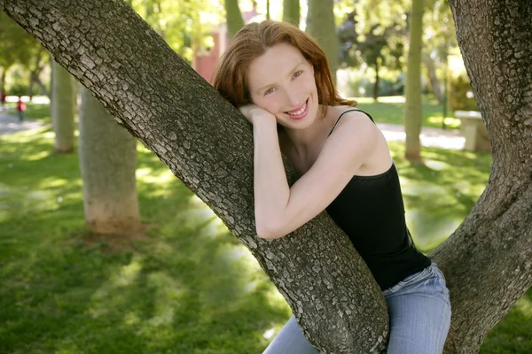 Park ağaç üzerinde oturan güzel kadın — Stok fotoğraf