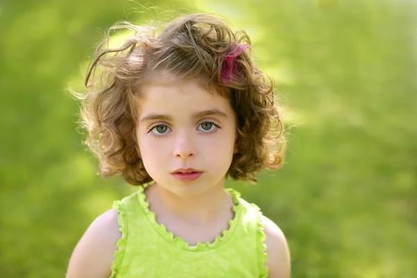 Όμορφη μελαχρινή μπλε μάτια μικρό κορίτσι πορτρέτο στο γρασίδι — Φωτογραφία Αρχείου