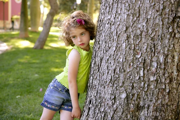 Hermosa niña morena junto a un tronco de árbol —  Fotos de Stock