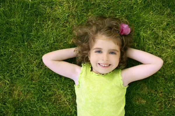 Krásná malá batole dívka šťastný, ležící na trávě — Stock fotografie