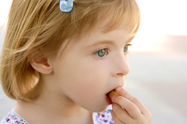 Blonde weinig meisje close-up portret koekje eten — Stockfoto