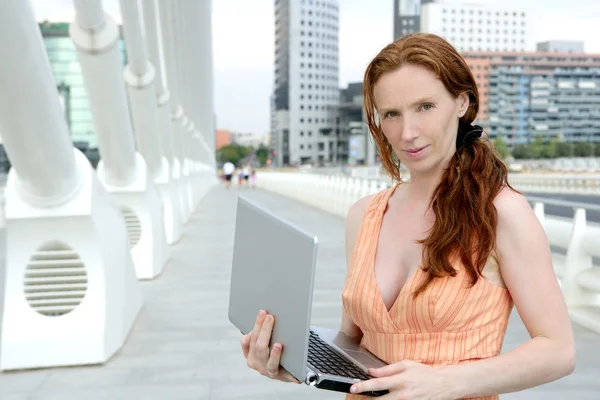 Schöne rothaarige Frau mit Laptop — Stockfoto