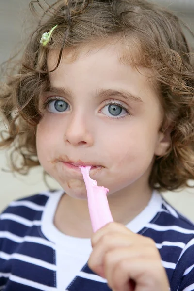 Küçük bir kız ile kirli yüzü tatlı şeker yemek — Stok fotoğraf