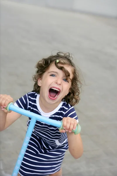 Брюнетка маленькая девочка со скутером в городе — стоковое фото