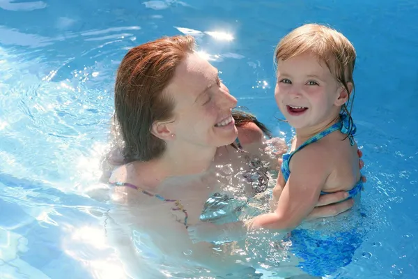Filha loira com mãe ruiva na piscina — Fotografia de Stock