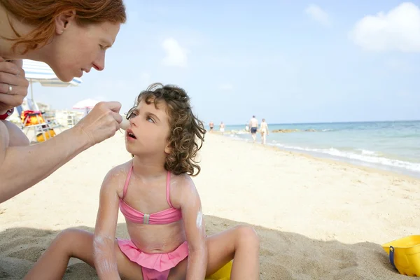 Plaj güneş ekran nem üzerinde anne ve kızı — Stok fotoğraf