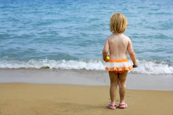 在海滩上的沙腿金发碧眼的小女孩 — 图库照片
