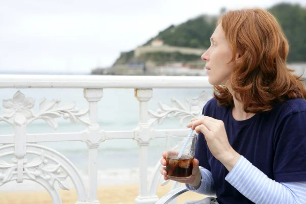 Gyönyörű vörös hajú nő iszik ital — Stock Fotó