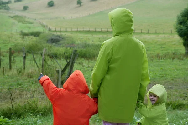 Zelená louka s vodotěsnou barevný kabát — Stock fotografie