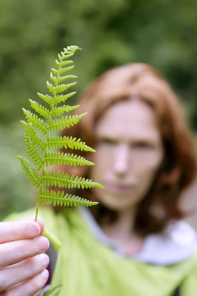 Ecology woman holding in hand green leaf — Stockfoto
