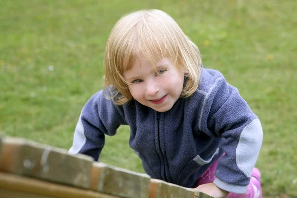 Bionda adorabile bambina che gioca al parco giochi — Foto Stock