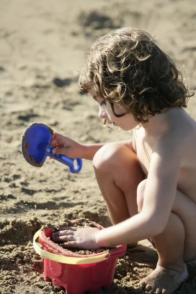 Belle petite fille jouant sur la plage — Photo