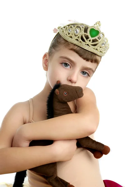 Красивая маленькая балерина обнимает игрушечную лошадь — стоковое фото