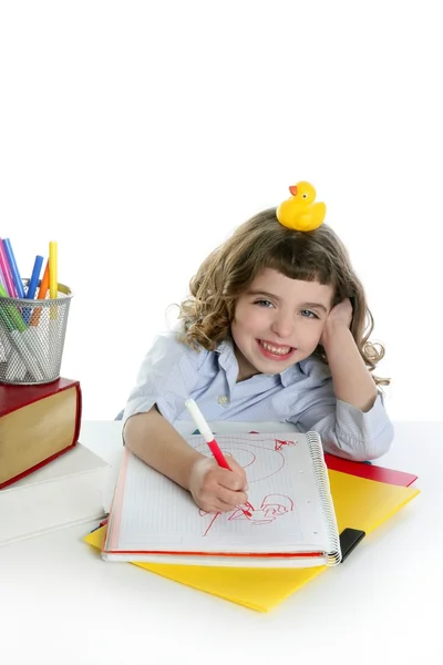 Маленькая девочка счастливая студентка на столе пишет — стоковое фото