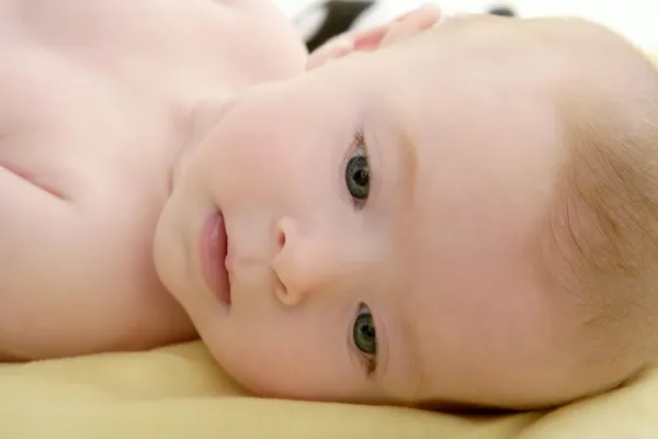 Blonda lilla bebis på sängen stående — Stockfoto