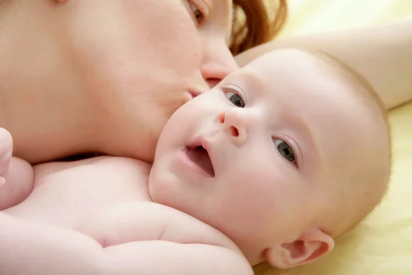 Mother kissing little baby smiling — Stock Photo, Image
