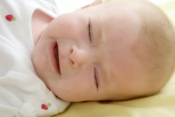 Грустный ребенок плачет лежа на кровати — стоковое фото
