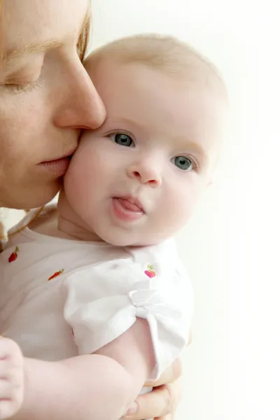 Mamma kysser lilla baby leende — Stockfoto