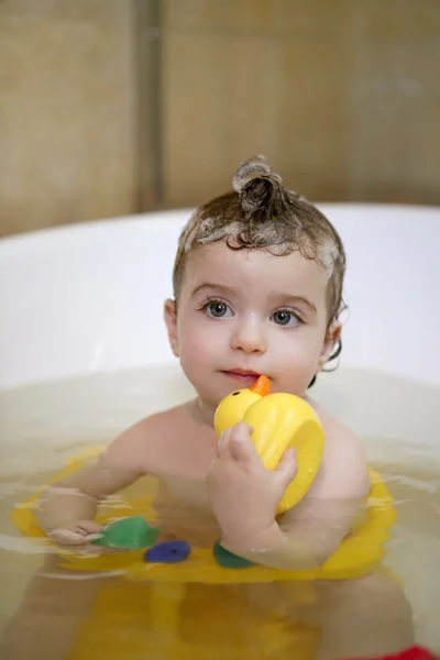 Bebê menina no banho jogando pato amarelo — Fotografia de Stock
