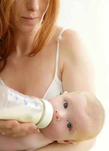 Baby drinking bottle from mother hands — Stock Photo, Image
