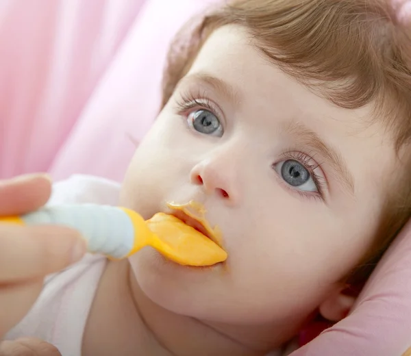 Annenin beslenme bebek sarı kaşık — Stok fotoğraf