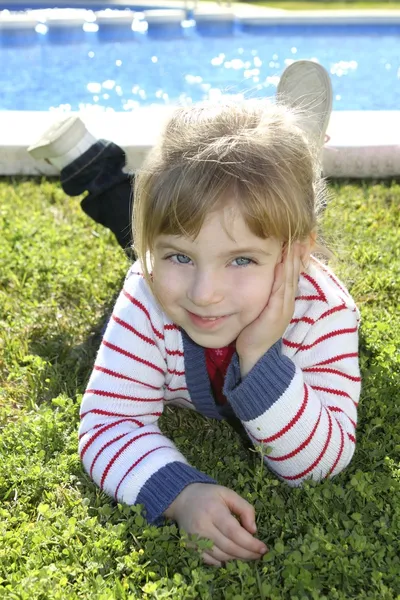 Blonďatá holčička na fond trávy představují — Stock fotografie