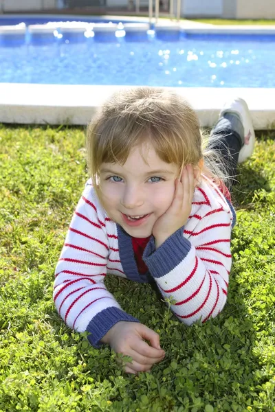 Blond liten flicka på pool gräs poserar — Stockfoto