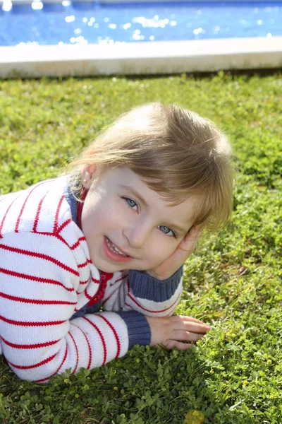 Blonďatá holčička na fond trávy představují — Stock fotografie