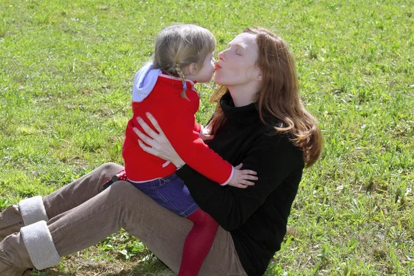 Mor och dotter kyssas läppar i äng — Stockfoto